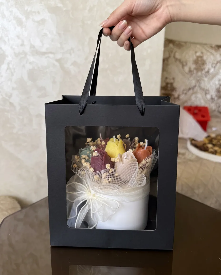 Le bouquet de tulipes en cire présenté dans un sac cadeau noir à fenêtre.